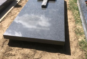 Masívny jednohrob s krížom z prírodného kameňa